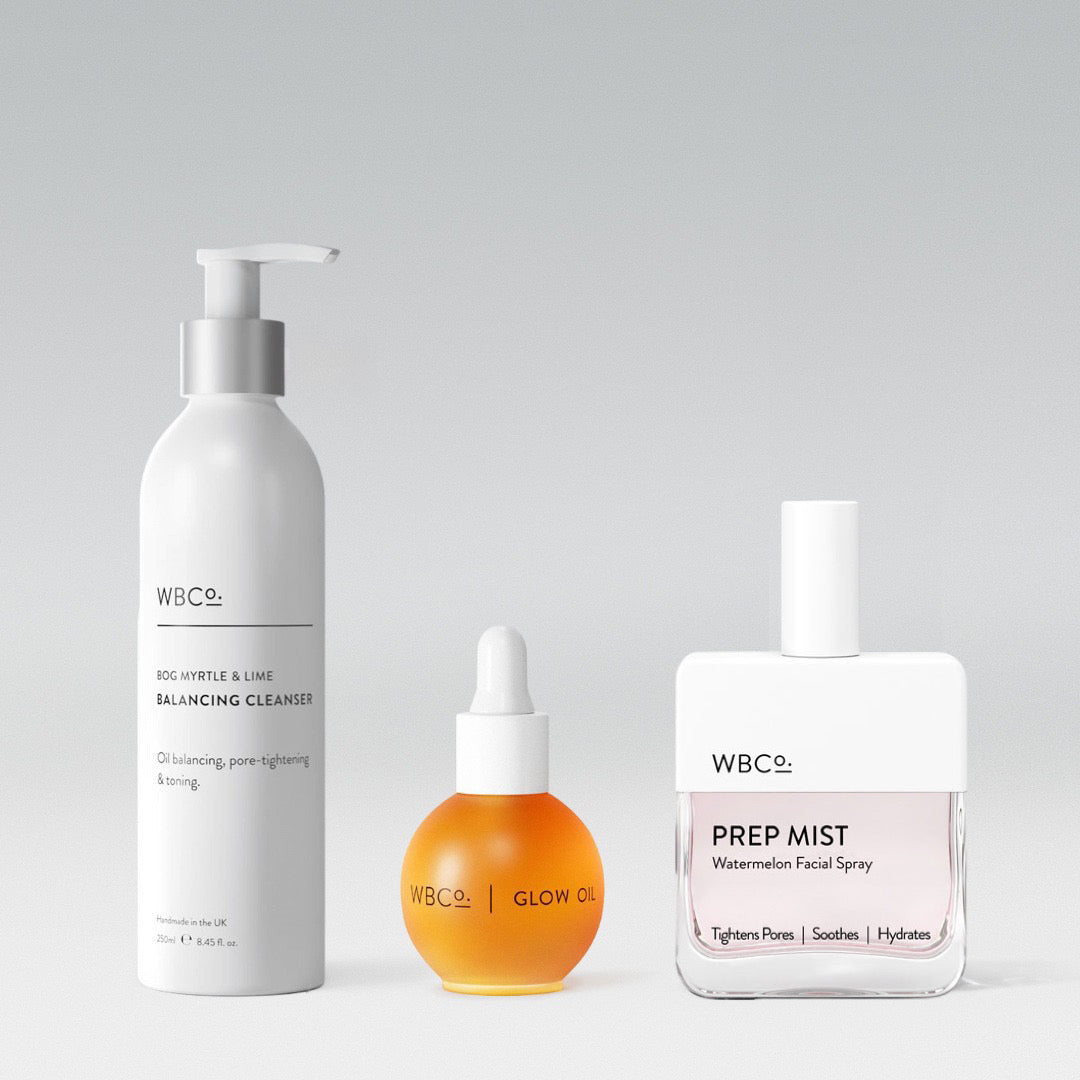 A set of three skincare products from WBCo, including a balancing cleanser in a white pump bottle, a glow oil in a round dropper bottle, and a prep mist in a spray bottle. facial spray is watermelon.